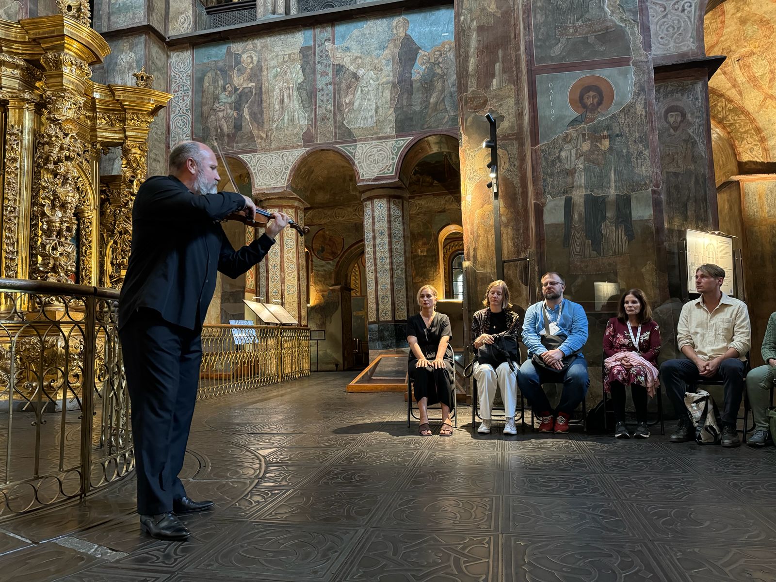 A violinist performs beneath the frescoes of St Sophia Cathedral