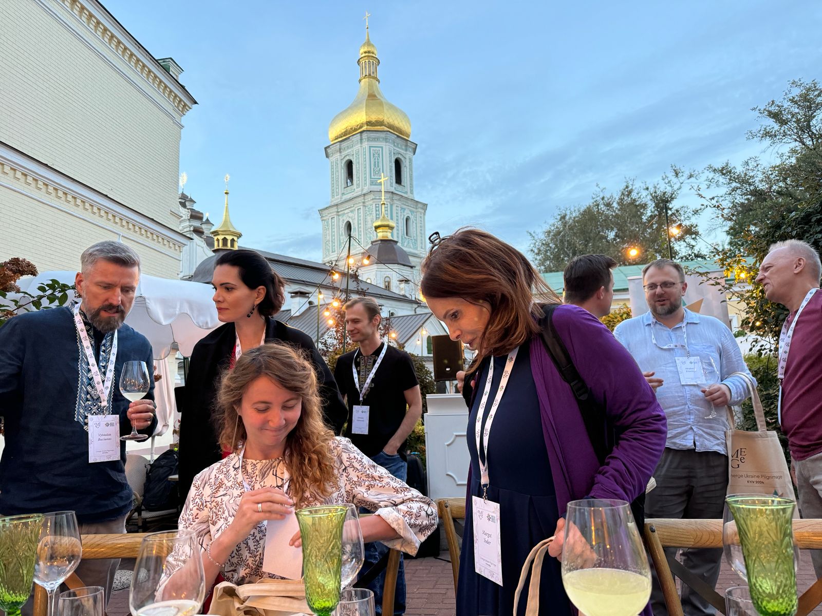 An evening rooftop gathering with wine at dusk, St Sophia's bell tower behind